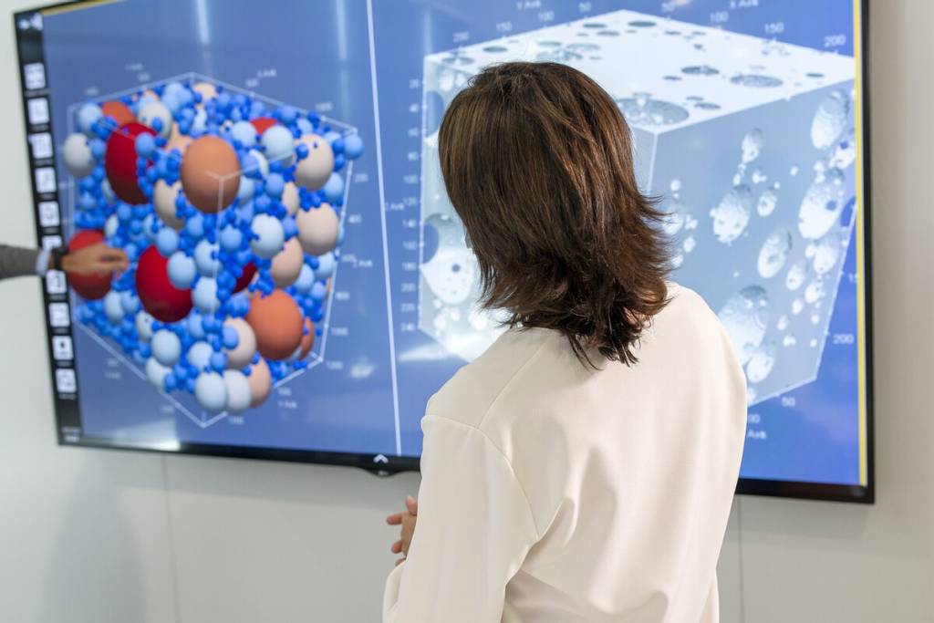 Scientists in a lab looking at a screen